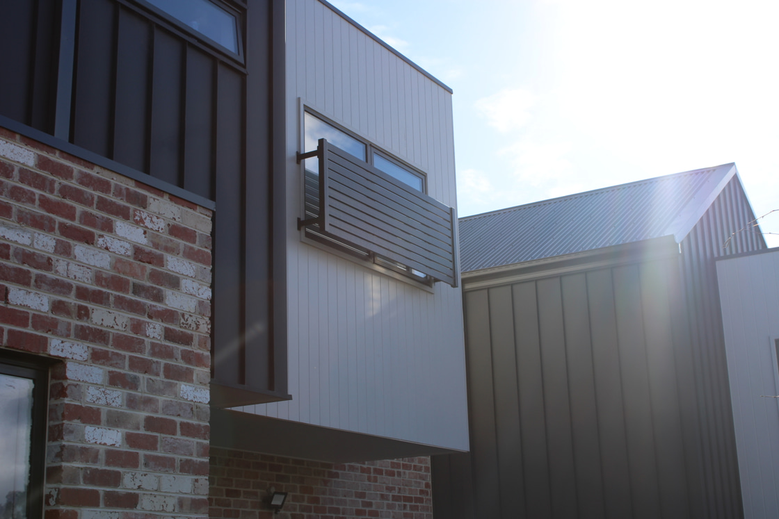 White James Hardie Axon cladding beside recycled brick and contrasting dark facade elements