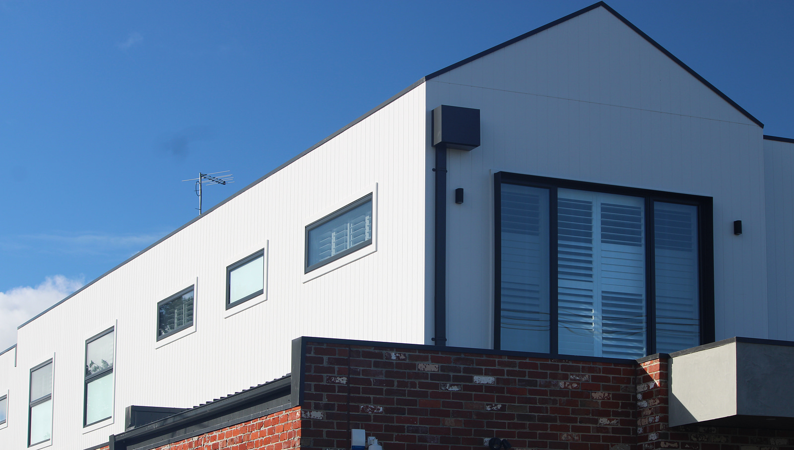 White James Hardie Axon vertically grooved cladding installed above recycled brickwork on a Melbourne home