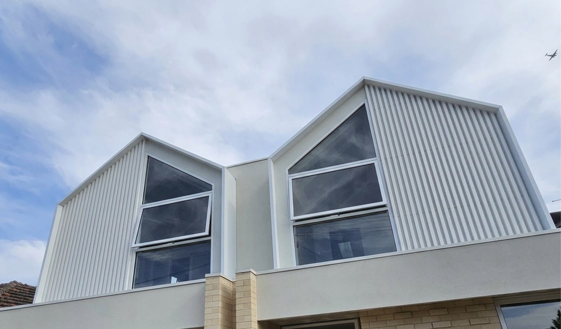 White aluminium battens framing two upper-storey gable windows on a Melbourne home