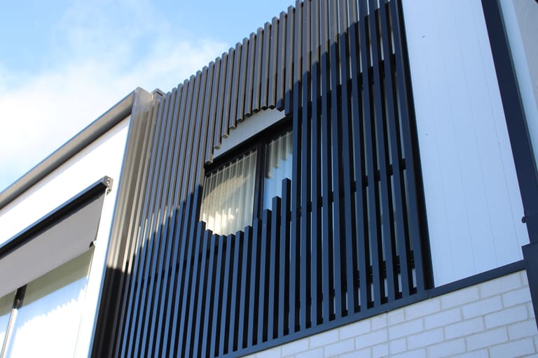 Black vertical battens screening a round window opening