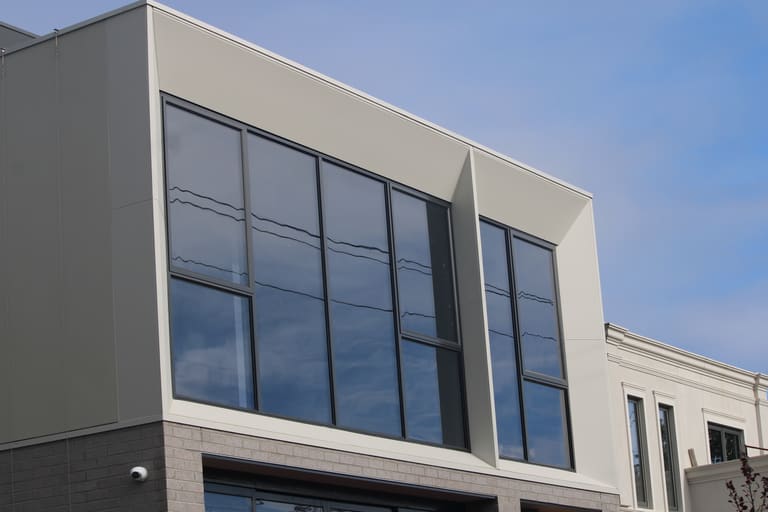 White panel-framed windows on a CLADSMAN-clad Melbourne townhouse