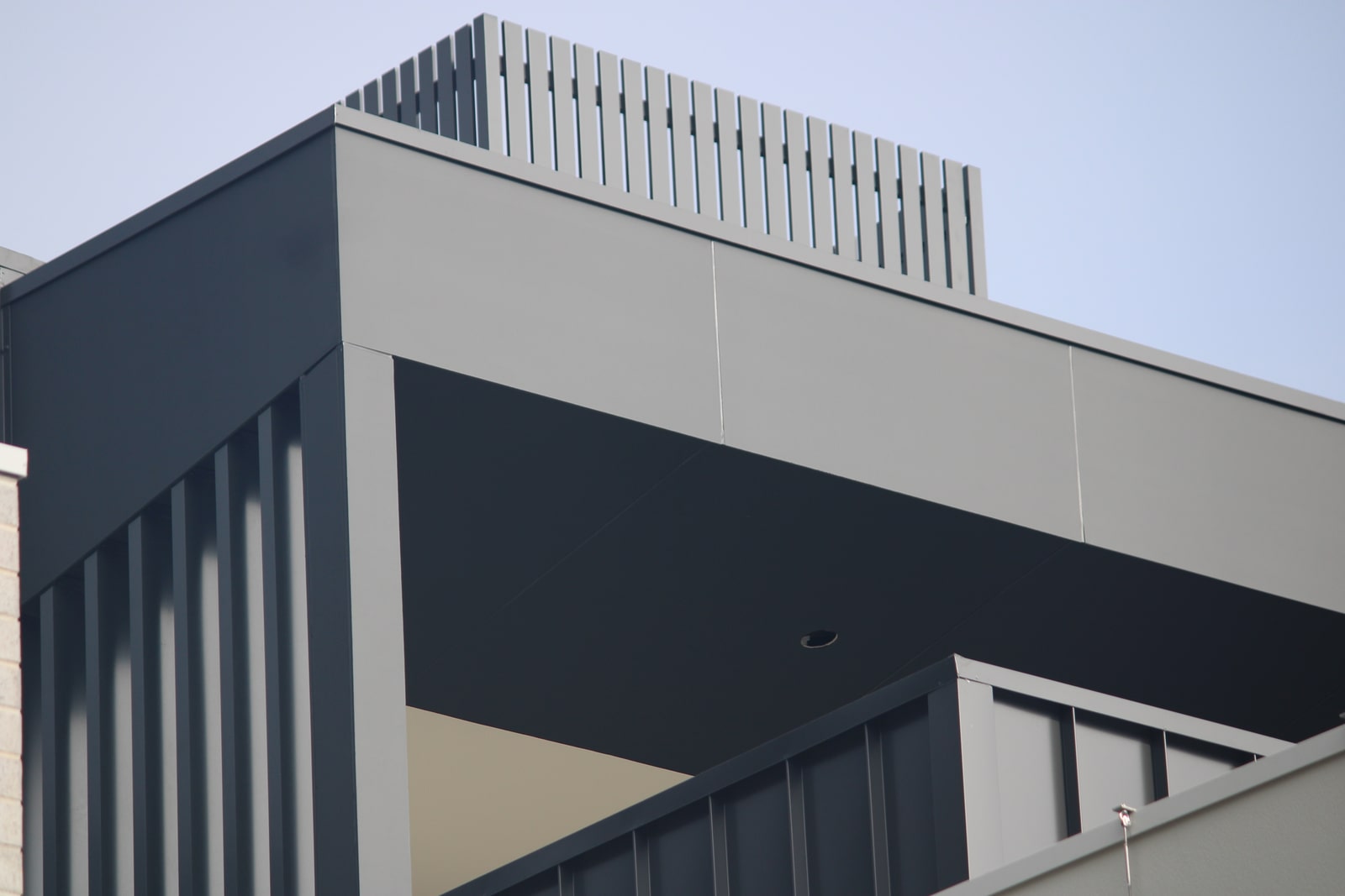Dark James Hardie Matrix fascia and soffit detailing beside a custom aluminium batten screen