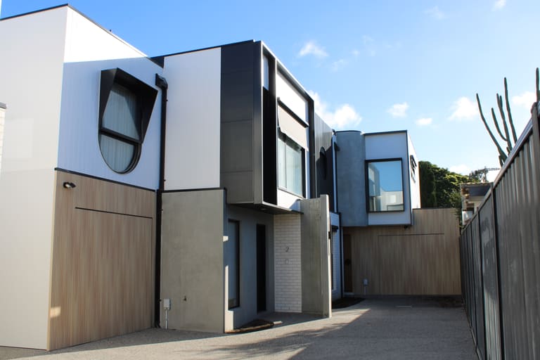 Courtyard with timber-look garage door and layered cladding