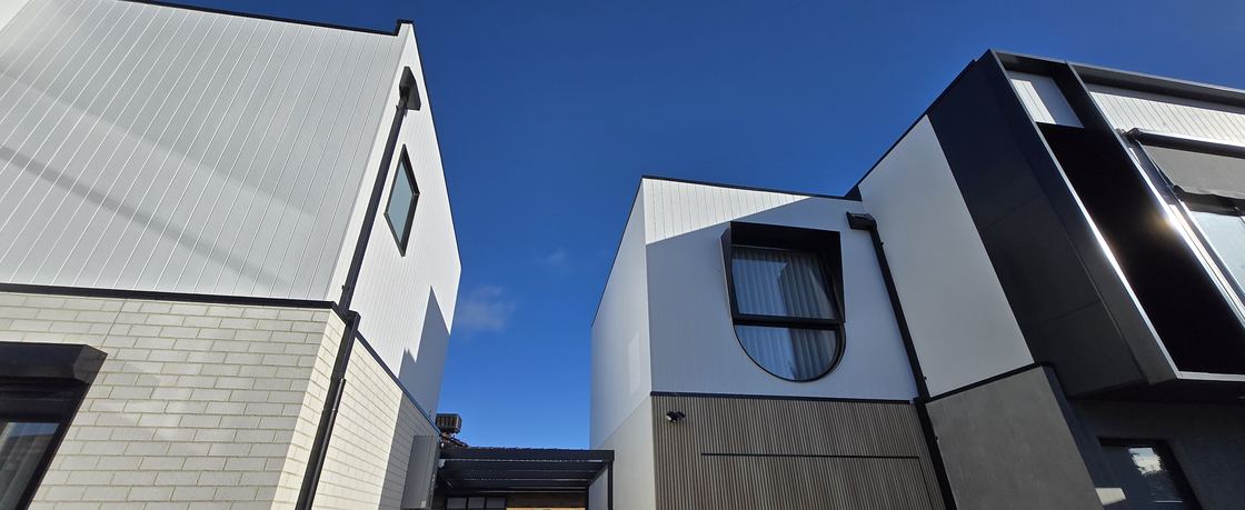 Townhouse facade with James Hardie Axon upper level cladding and NewTechWood Cedar castellation cladding to the garage and lower feature facade